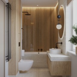 Aneta Eron - Elegancka łazienka z drewnianymi panelami, owalnym lustrem z podświetleniem i designerską lampą. Minimalistyczny styl, jasne kolory, nowoczesne wyposażenie.