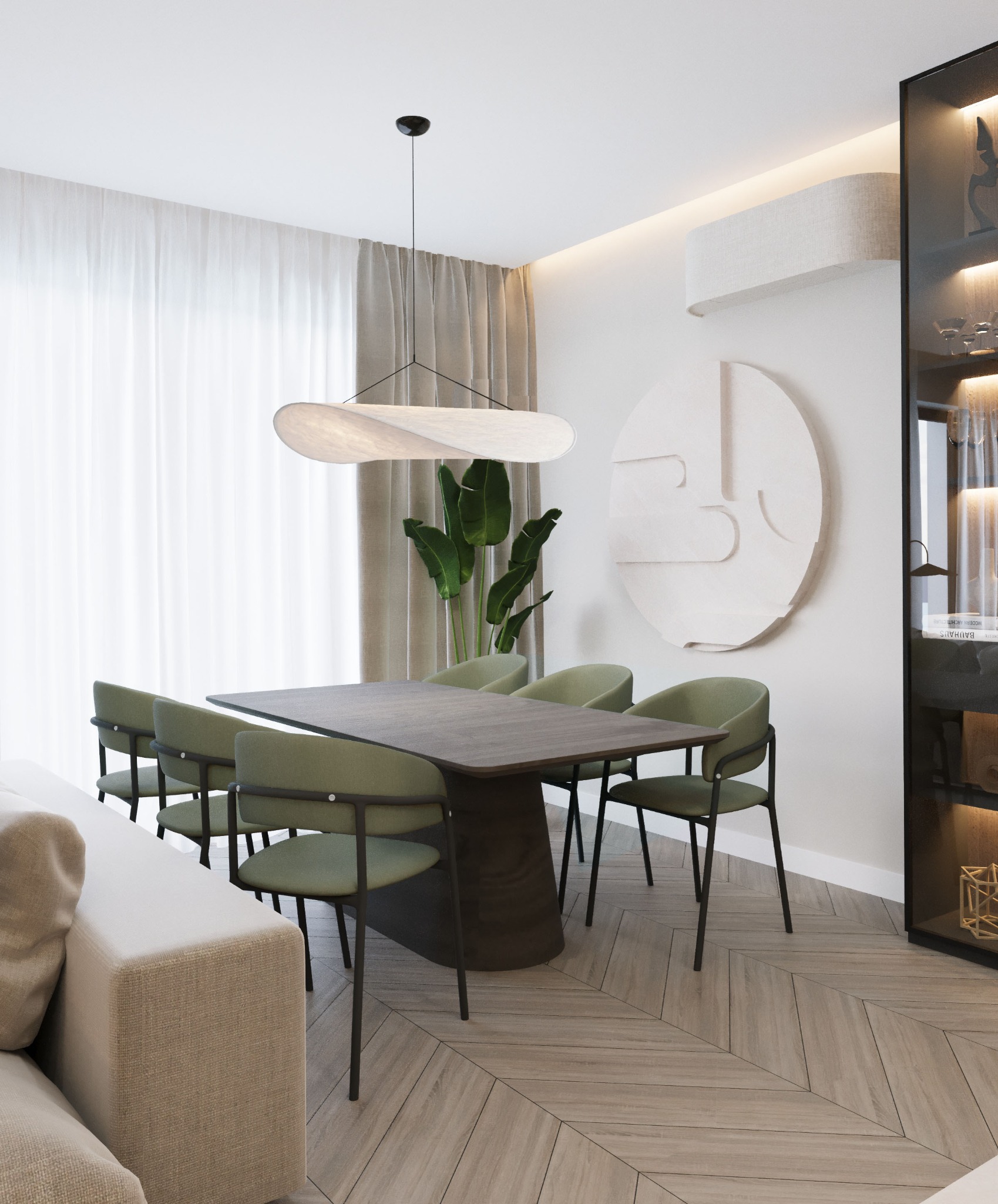 Nowoczesna jadalnia z drewnianym stołem, zielonymi krzesłami i designerską lampą. Parkiet ułożony w jodełkę, dekoracja ścienna i roślina dodają wnętrzu charakteru.