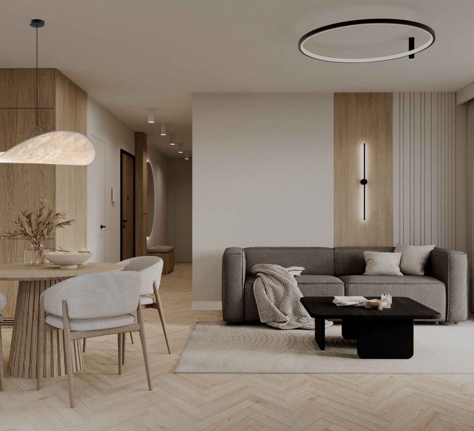 Eleganckie wnętrze: okrągły stół z dekoracją, szara sofa z pledem i czarny stolik kawowy na parkiecie w jodełkę. Subtelne oświetlenie i drewniane akcenty.
