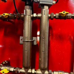 KTR SYSTEM KATARZYNA CZOCHARA - Czerwony zbiornik z dwoma mosiężnymi rozdzielaczami Minimax, z żółtymi zaworami, podłączonymi przewodami i czujnikiem. Element instalacji grzewczej.