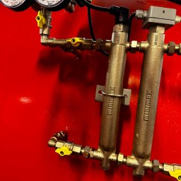 KTR SYSTEM KATARZYNA CZOCHARA - Czerwony zbiornik z manometrami i instalacją hydrauliczną z żółtymi zaworami. Widoczne filtry z oznaczeniem Reflex.