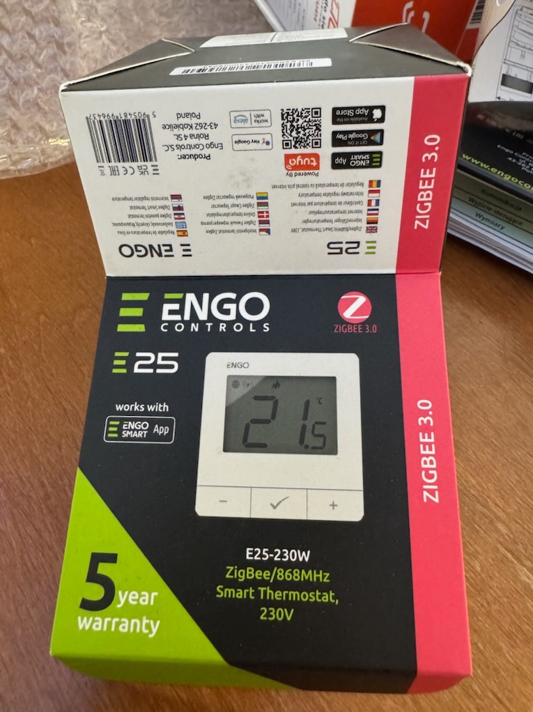 Pudełko termostatu ENGO E25-230W ZigBee/868MHz. Produkt nowy, z 5-letnią gwarancją. Widoczny wyświetlacz termostatu z temperaturą 21.5°C i przyciski sterowania.