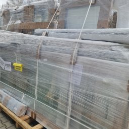 MAK Consulting p.h.u. Michał Nowak - Stos okien PCV marki Drutex, zabezpieczonych folią, na palecie w Siemianowicach Śląskich. Widoczna etykieta z akcesoriami i oznaczeniami producenta.