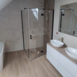 WM Sylwester Zawada - Nowoczesna łazienka na poddaszu z kabiną prysznicową typu walk-in, umywalkami nablatowymi i lustrem z podświetleniem LED. Jasne płytki imitujące drewno na podłodze.