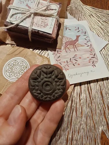 Ręcznie robione mydło z ozdobnym stemplem, ułożone z kartką z motywem jelenia i podziękowaniem, tworzy zestaw prezentowy w naturalnych barwach.