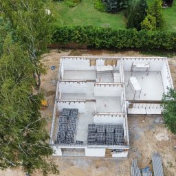 jjuuhuujggygv by hb - Fundamenty domu jednorodzinnego z betonu komórkowego, widziane z góry w Niemcach. Częściowo wzniesione ściany, rusztowania i bloczki. Etap budowy.