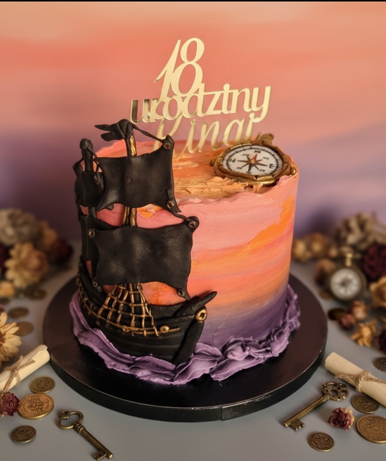 Tort urodzinowy w stylu pirackim: statek z czarnymi żaglami, kompas i topper '18 urodziny'. Pastelowe tło i dekoracje z monet i kluczy dodają uroku.