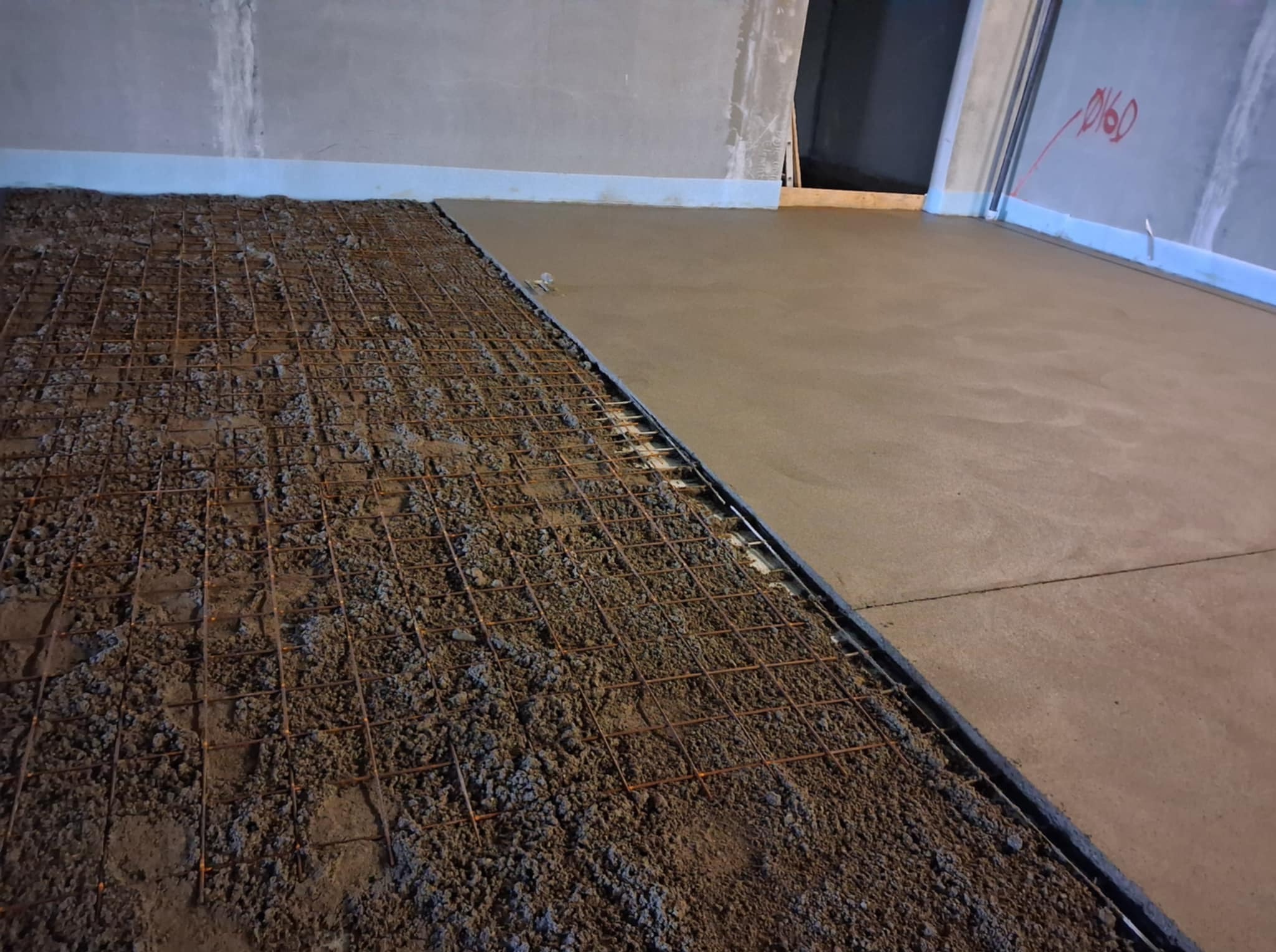 Połowa powierzchni zbrojona siatką, druga wylana jastrychem. Widoczne przygotowanie podłoża i fragment gotowej posadzki.