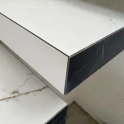 Biało-czarne stopnie schodów z marmurowym wzorem, wykończone z dbałością o detal, ukazane z bliska pod kątem, podkreślającym elegancję i nowoczesny design.