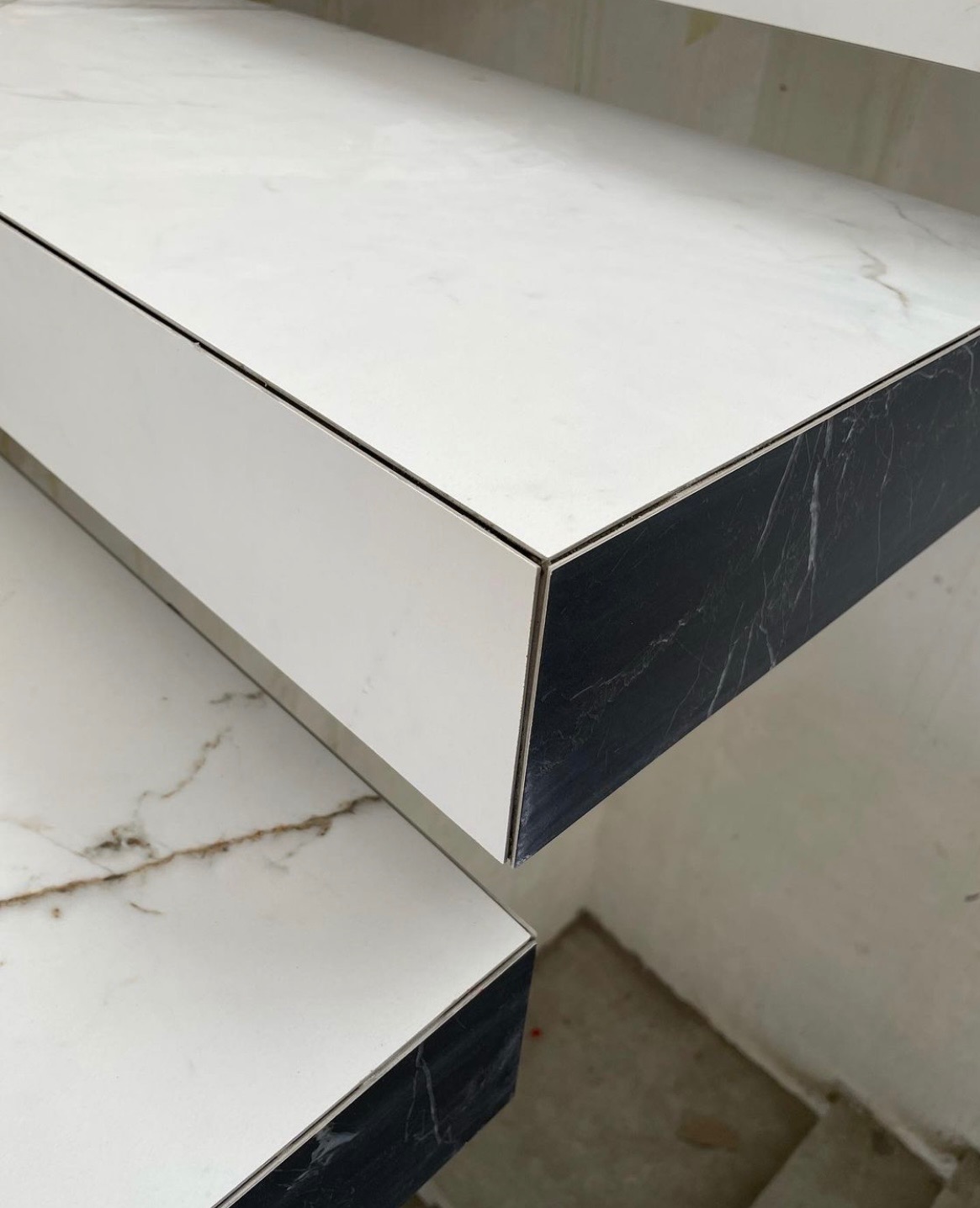 Biało-czarne stopnie schodów z marmurowym wzorem, wykończone z dbałością o detal, ukazane z bliska pod kątem, podkreślającym elegancję i nowoczesny design.