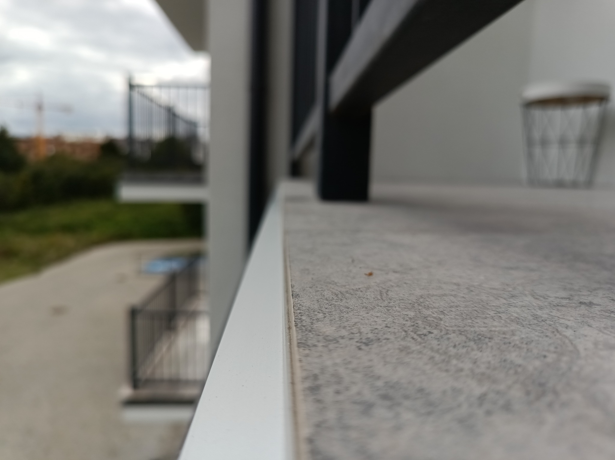 Nowa posadzka z kafli na balkonie, wykończona listwą okapową.