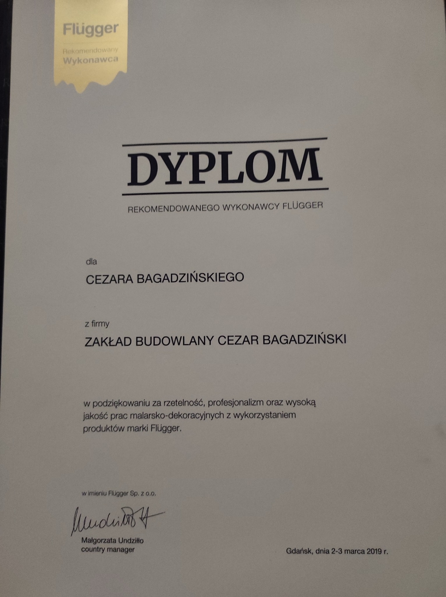 Dyplom dla Cezara Bagadzińskiego od Flügger za rzetelność w pracach malarsko-dekoracyjnych, podpisany przez Małgorzatę Undziłło, Gdańsk, 2-3 marca 2019.