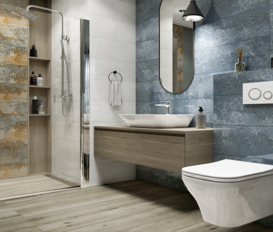 Nowoczesna łazienka z kabiną typu walk-in, umywalką nablatową i toaletą podwieszaną. Niebieskie i białe płytki imitujące kamień oraz drewnopodobna podłoga.