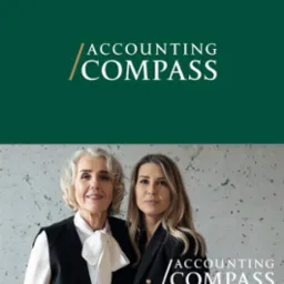 Portret dwóch uśmiechniętych kobiet na tle betonowej ściany z logo firmy Accounting Compass. Profesjonalny wizerunek zespołu biura rachunkowego.