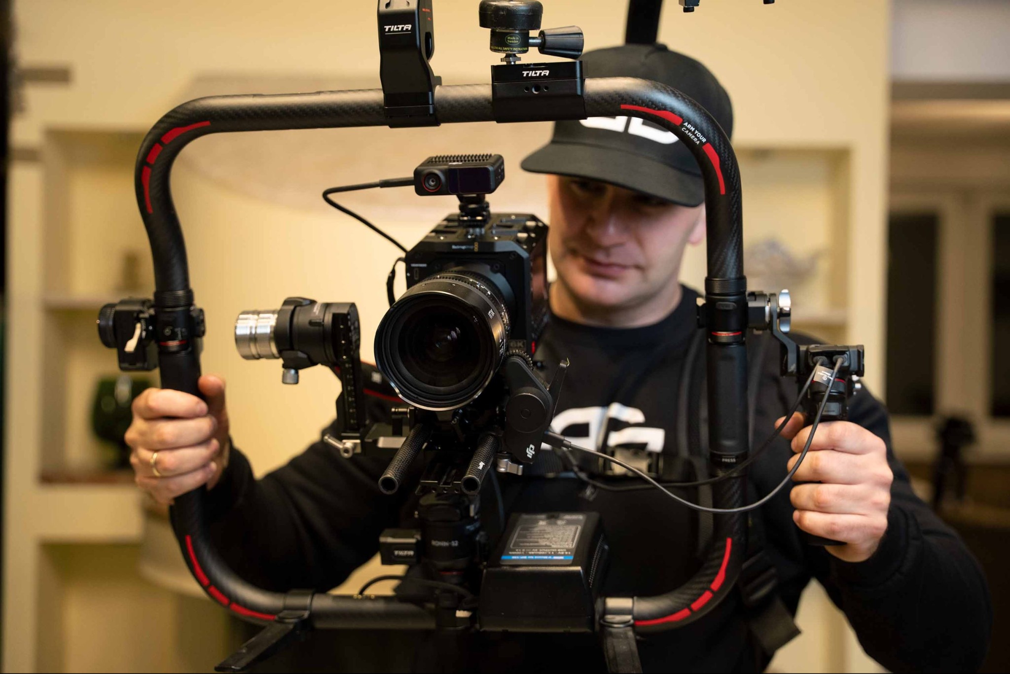 Operator z Lublina obsługuje profesjonalny stabilizator kamery z zamontowanym aparatem i dodatkowym osprzętem, przygotowując się do nagrania ujęcia.