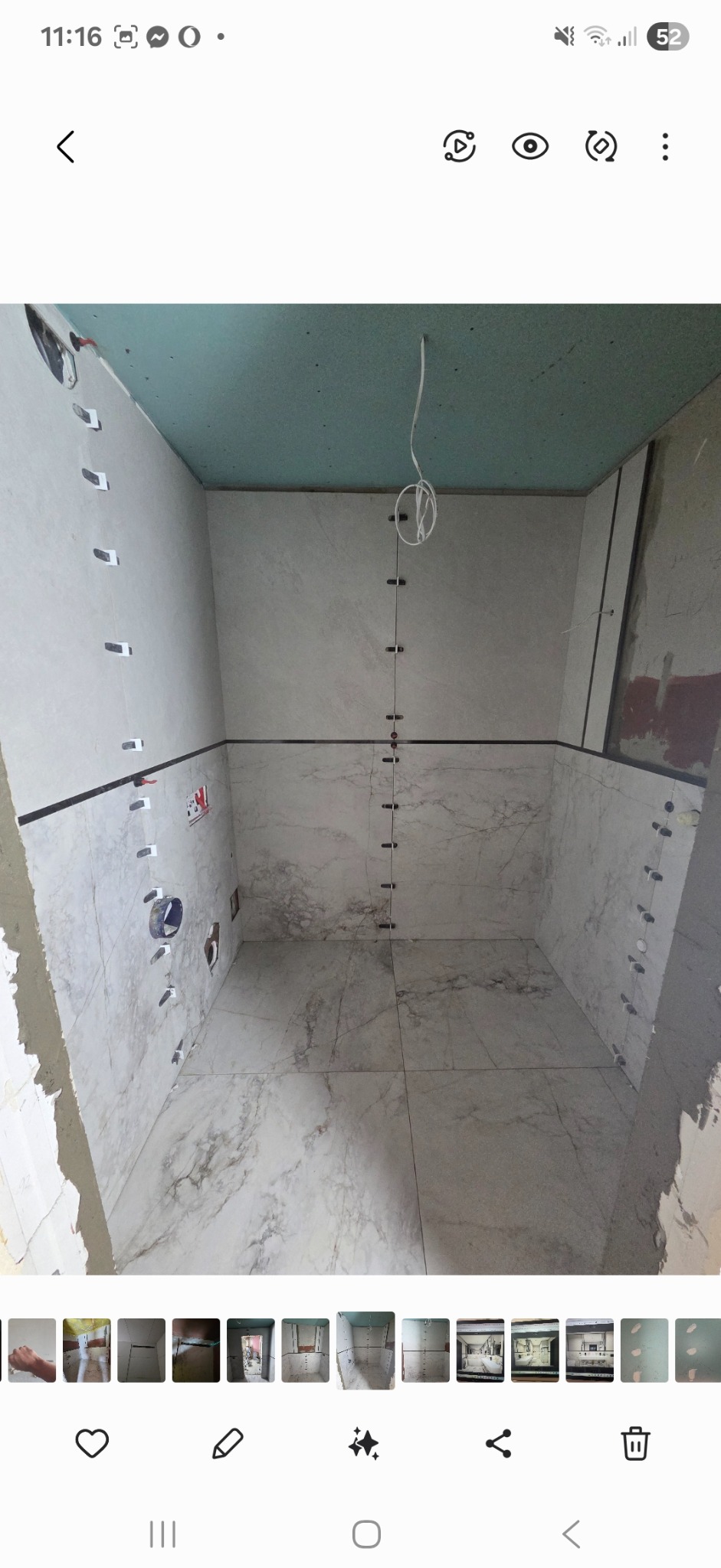 Łazienka w trakcie wykończenia w Raba Niżna: ułożone płytki imitujące marmur na podłodze i ścianach, widoczne elementy instalacji wodnej i poziomowania płytek.