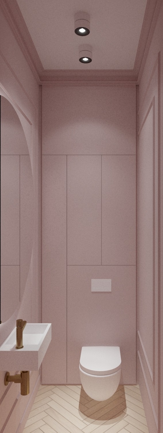 Minimalistyczna łazienka w pudrowym różu z białym sanitariatem, złotą armaturą i parkietem w jodełkę. Dwa punktowe światła sufitowe.