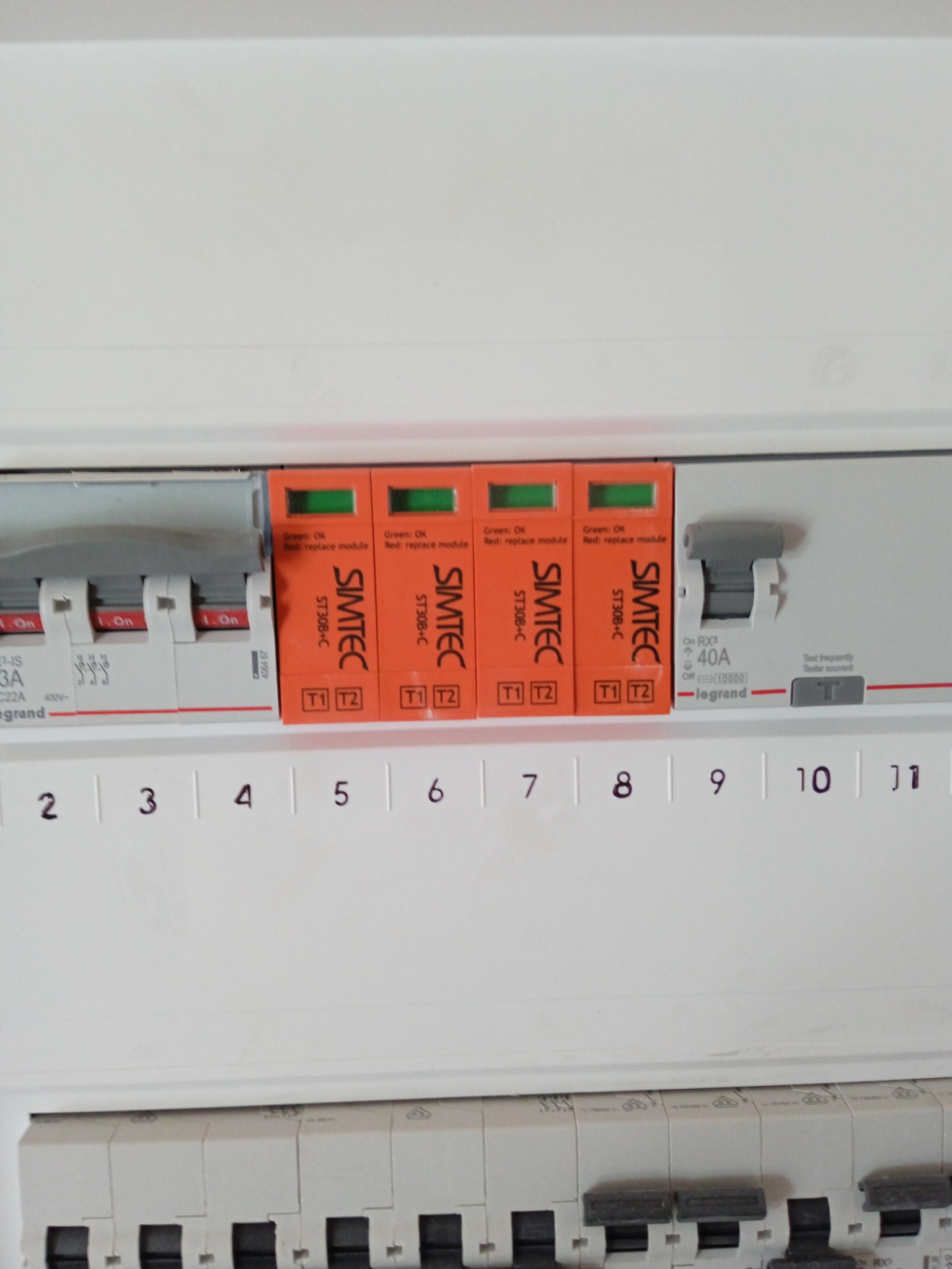 Rozdzielnica elektryczna z zabezpieczeniami przeciwprzepięciowymi Simtec ST30B-C, z modułami oznaczonymi T1 i T2. Widoczne bezpieczniki i oznaczenia amperażu.