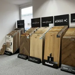 Ekspozycja paneli podłogowych Berry Alloc i Hobuco w sklepie: różne wzory i kolory, w tym jodełka. Prezentacja paneli winylowych Bordo.