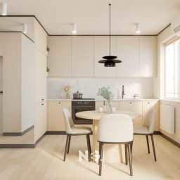 NEG DESIGN NATALIA GRZYWACZ - Jasna kuchnia z okrągłym stołem i trzema krzesłami. Minimalistyczny design, beżowe szafki i drewniana podłoga. Czarny, designerski żyrandol nad stołem.