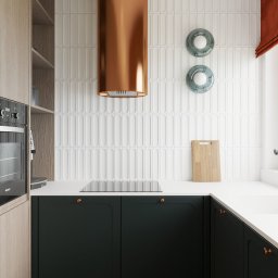 Twoje Nowe Studio Projektowe Ewa Kromska - Nowoczesna kuchnia z ciemnozielonymi szafkami, drewnianym blatem i miedzianym okapem. Na ścianie białe, podłużne płytki i drewniana deska do krojenia.