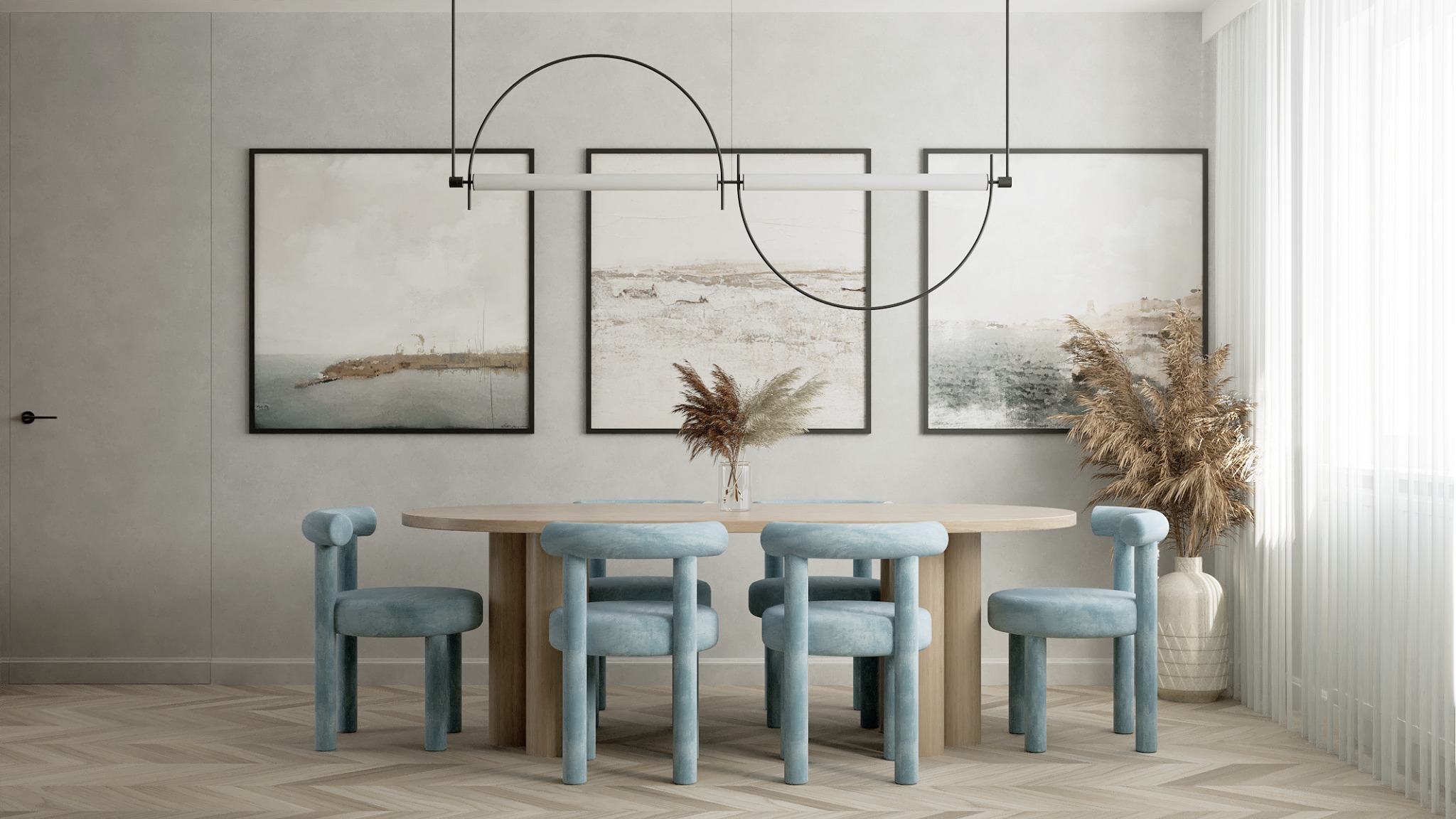 Jasne wnętrze jadalni: okrągły stół z drewnianym blatem i błękitnymi krzesłami. Nad nim lampa z czarnymi łukami, na ścianie trzy obrazy w czarnych ramach.