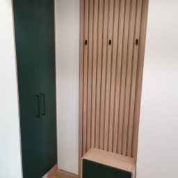 SKLEP MEBLOWY MIX ADRIAN KUSSA - Nowoczesna zabudowa przedpokoju w Tychach: ciemnozielona szafa wnękowa z czarnymi uchwytami i panel z drewnianych listew z wieszakami oraz siedzisko.