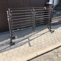 TopMetalWork - Surowa, metalowa konstrukcja dwuskrzydłowej bramy wjazdowej z poziomymi szczeblami, przygotowana do montażu na posesji z brązową bramą.
