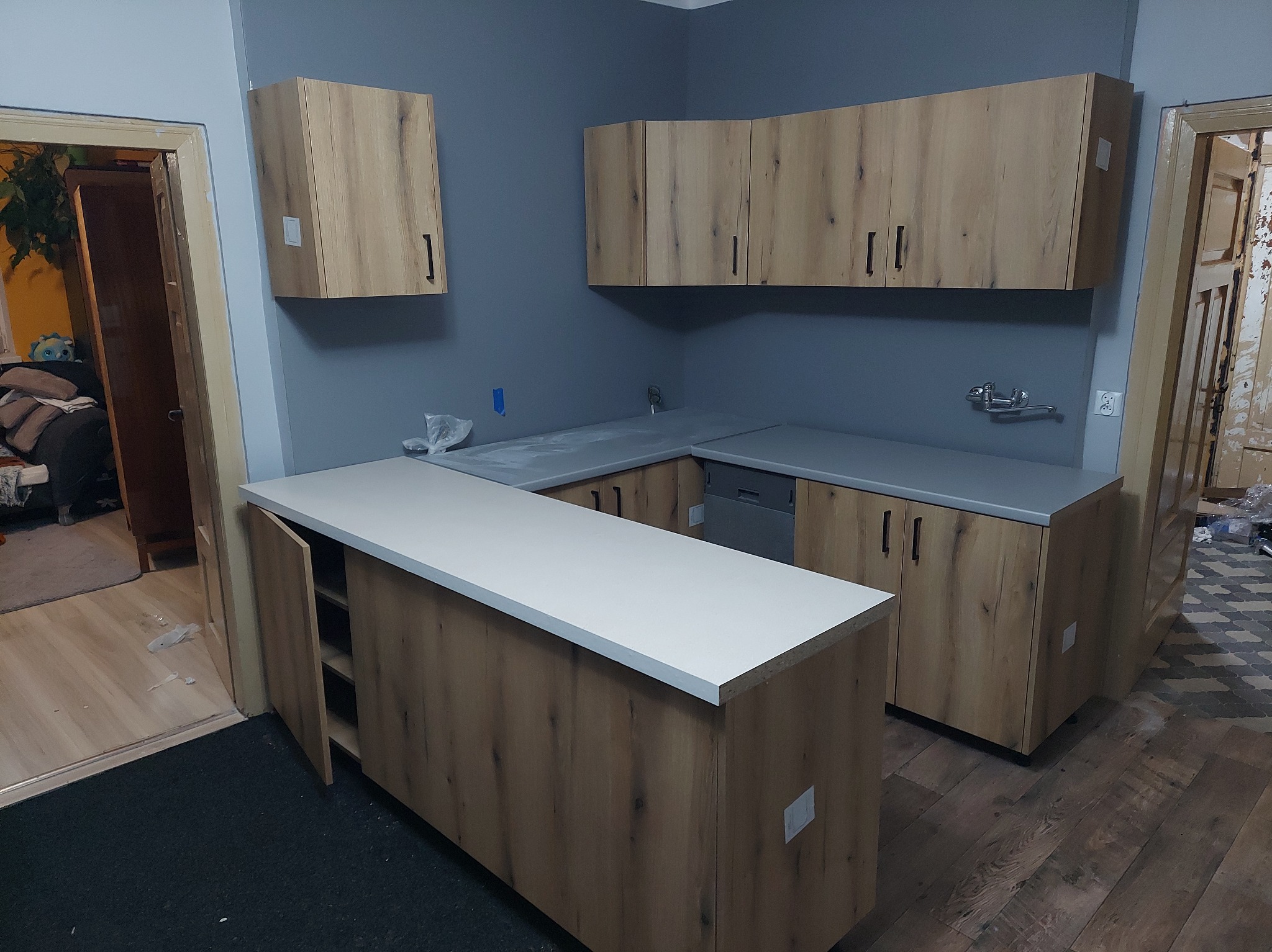 Zabudowa kuchenna w kształcie litery U z szafkami wiszącymi.