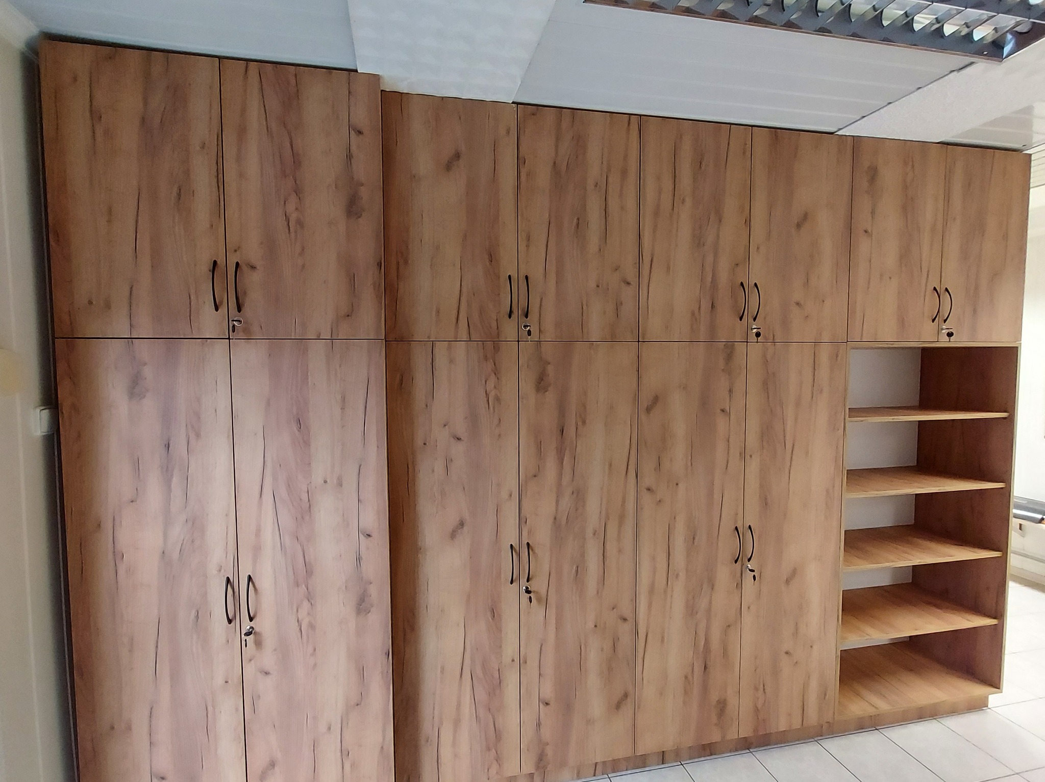 Zabudowa biurowa z półkami pod dokumenty.