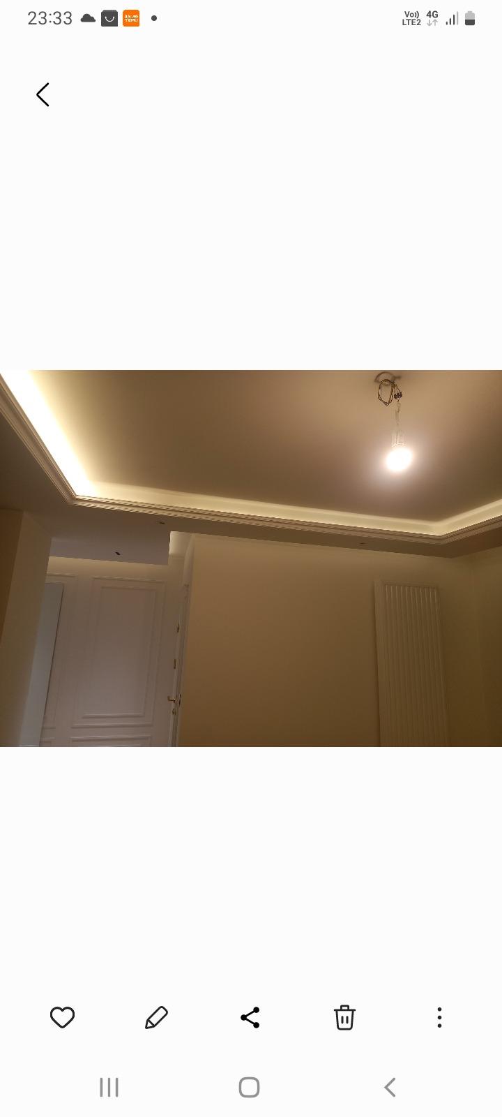 Wykończone wnętrze z oświetleniem LED podsufitowym, kremowe ściany, białe drzwi z dekoracyjnymi panelami i grzejnik. Widok z dołu, włączone światło.