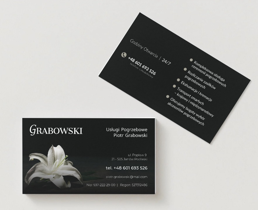 Dwie czarno-białe wizytówki z danymi firmy pogrzebowej Grabowski, z numerem telefonu, adresem e-mail i grafiką białej lilii.