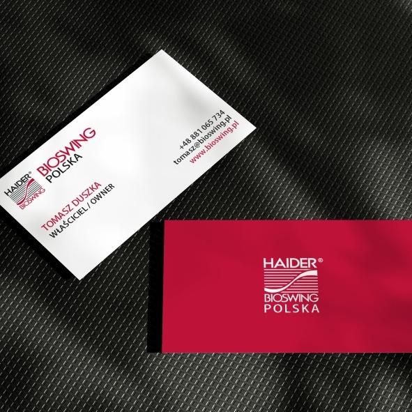 Dwie wizytówki firmy Haider Bioswing Polska na teksturowanym, ciemnym tle. Jedna biała z czerwonym logo i danymi kontaktowymi, druga czerwona z białym logo.