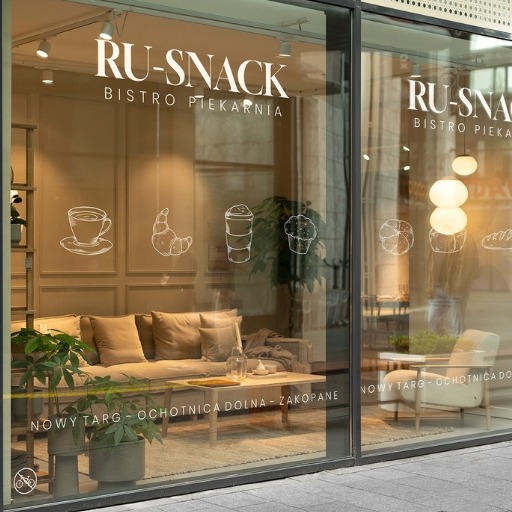 Grafika na witrynie bistro-piekarni 'RU-SNACK' z rysunkami kawy, rogalika i muffina. Widoczne wnętrze lokalu z kanapą i stolikiem. Napis 'NOWY TARG - ... - ZAKOPANE'.