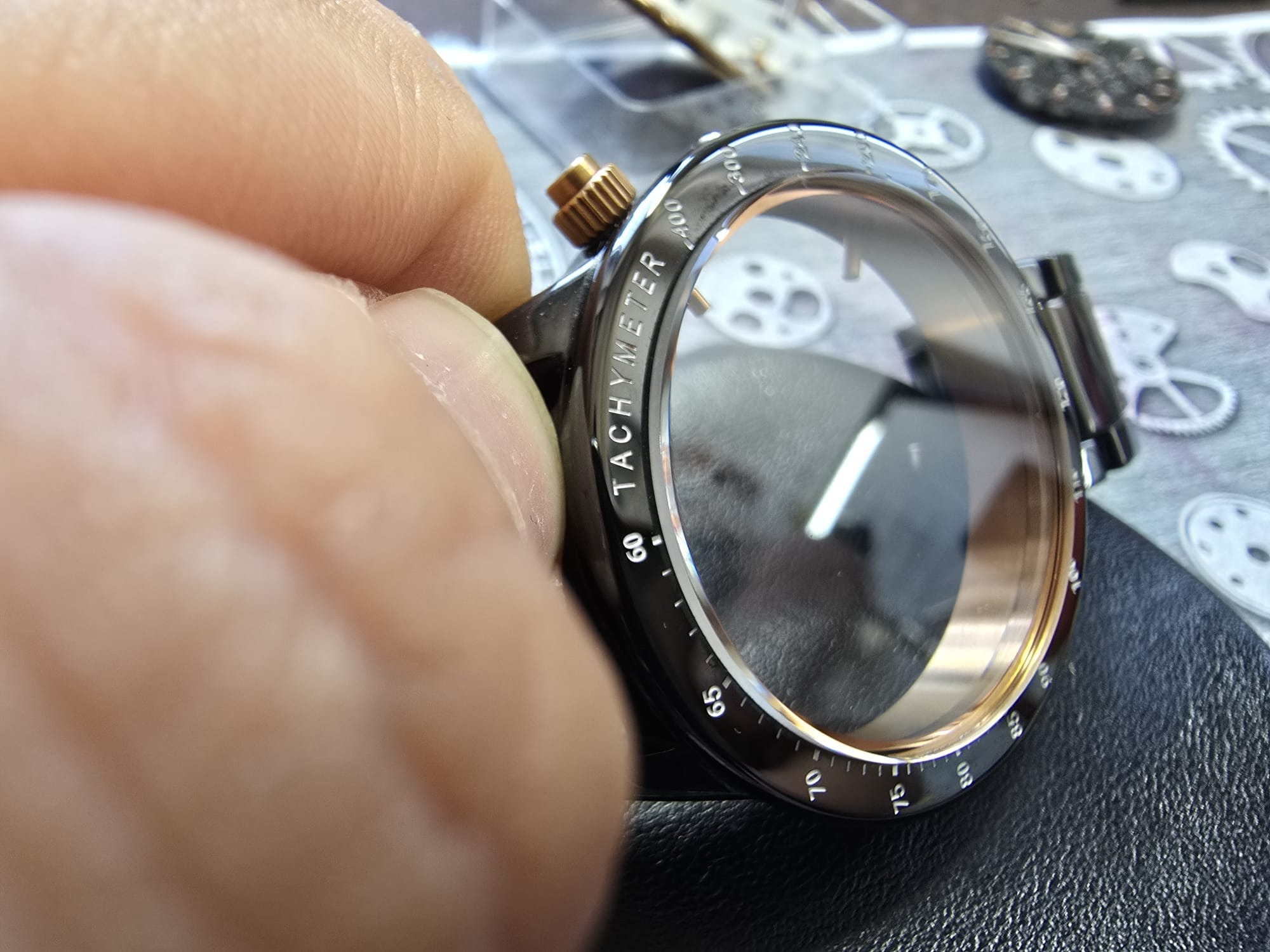 Czyszczenie zegarka z tachymetrem. Drobne elementy zegarmistrzowskie w tle. Zbliżenie na delikatną pracę rąk przy naprawie zegarka. Precyzja i dbałość o detale.