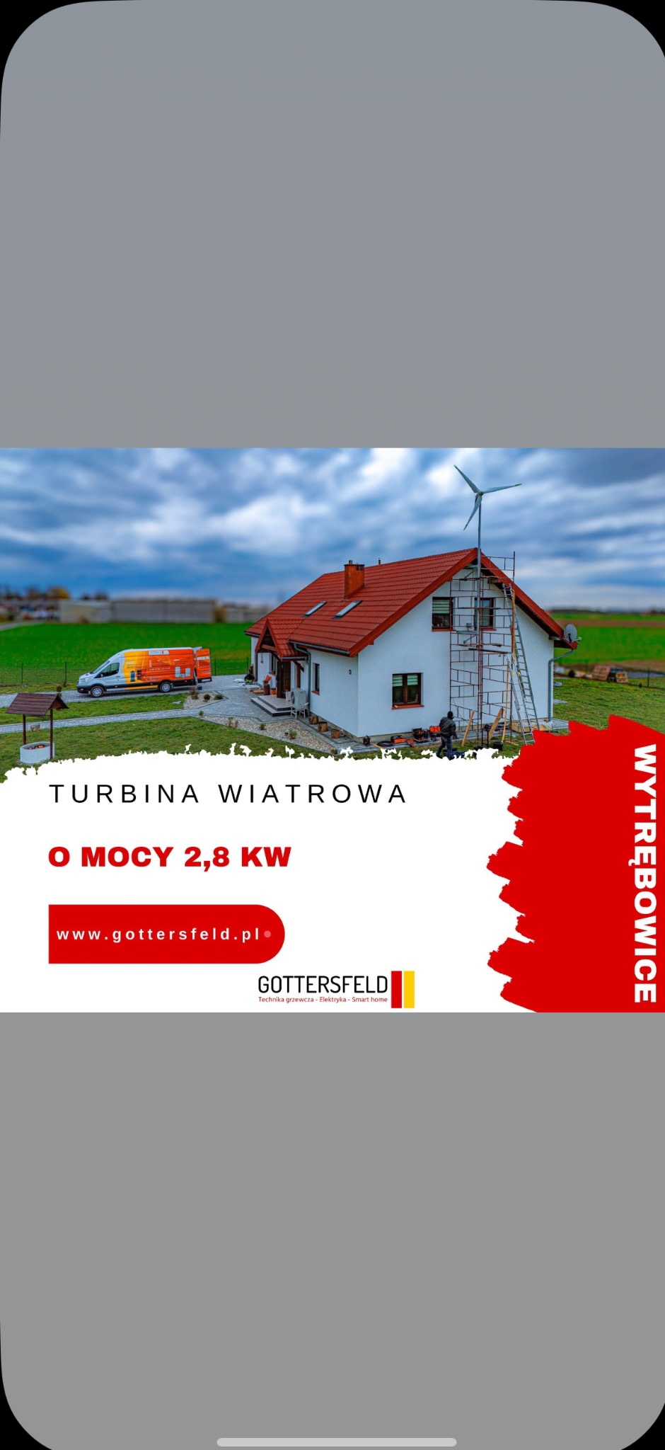 Turbina wiatrowa 2,8 kW zamontowana na dachu domu jednorodzinnego. Na tle błękitne niebo i firmowy van. Reklama firmy Gottersfeld z Wytrębowic.