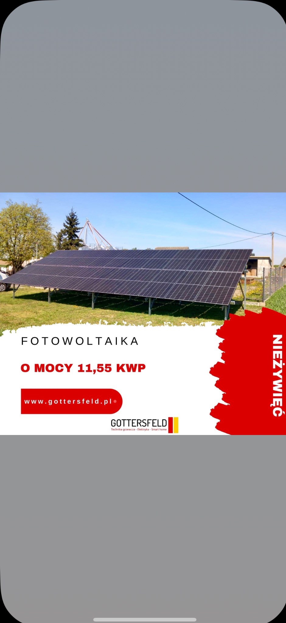 Instalacja fotowoltaiczna o mocy 11,55 kWp na zielonej działce, w tle budynki i drzewa. Reklama firmy Gottersfeld z Nieżywięcia.