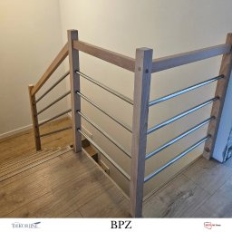 ZAB-DEKOR Arkadiusz Zabdyr - Minimalistyczna, jasna drewniana konstrukcja z metalowymi prętami na schodach. Naturalne drewno i proste linie tworzą nowoczesny wygląd.