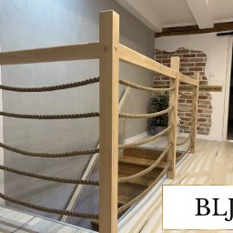 ZAB-DEKOR Arkadiusz Zabdyr - Drewniana balustrada schodowa z linami w roli wypełnienia, jasne drewno, nowoczesny design, widok z dołu schodów, wnętrze domu.