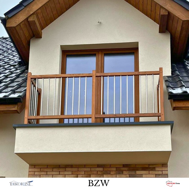Balkon z drewnianą ramą i metalowymi prętami balustrady, widok z dołu. Nowoczesny design, brązowe okno, beżowa elewacja, czarny dach.