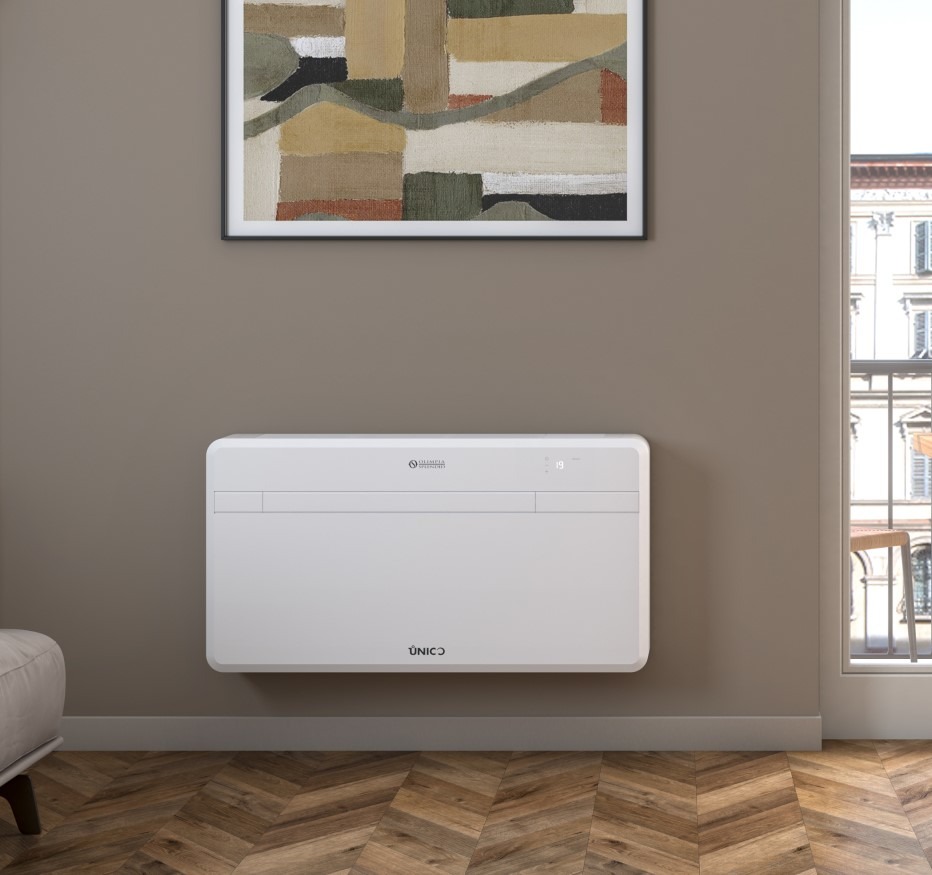 Biała klimatyzacja UNICO na ścianie w salonie z parkietem w jodełkę, obrazem i widokiem na miasto przez okno. Nowoczesny design, estetyczne wykończenie.