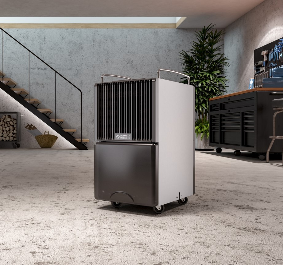 Przenośny klimatyzator Olimpia Splendid na kółkach w garażu w Białymstoku, na tle schodów i narzędzi. Nowoczesny design, szaro-biała kolorystyka, widoczne logo producenta.