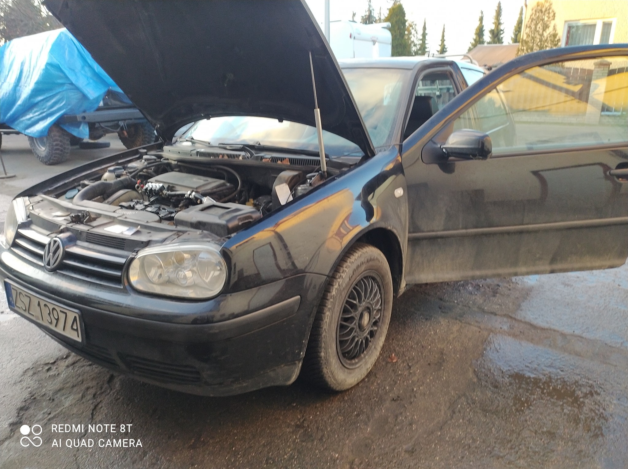 Czarny Volkswagen Golf z otwartą maską, widoczny silnik. Uwagę zwraca instalacja LPG. Otwarta boczna szyba. Zarejestrowany w Polsce. Lekko zabrudzony.