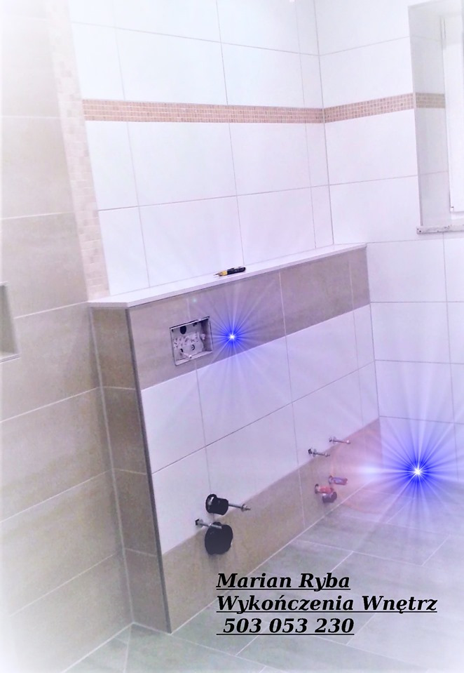 Wykończona łazienka w Międzylesiu: biało-beżowe płytki, zabudowa podtynkowego WC, widoczne przyłącza wodne i narzędzie glazurnicze na półce.