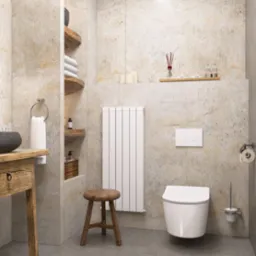 Stylowa łazienka z umywalką na drewnianym blacie, półkami z ręcznikami i dekoracjami, grzejnikiem i toaletą. Utrzymana w jasnej kolorystyce z akcentami drewna.