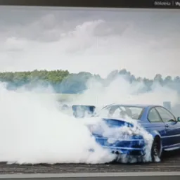 Niebieskie BMW E46 w intensywnym dymie podczas driftu, uchwycone w programie do edycji zdjęć. Widoczne ustawienia ekspozycji i histogram.