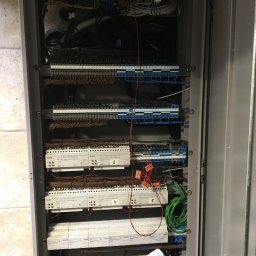 Braim Company Sp z o.o - Otwarta szafa sterownicza z modułami, listwami zaciskowymi i okablowaniem. Widoczne numery na modułach, przewody w różnych kolorach.