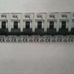 Jarosław Barański - Rozdzielnica elektryczna z wyłącznikami nadprądowymi marki Ideal, widoczne oznaczenia i parametry techniczne. Jeden wyłącznik w pozycji ON, reszta OFF.
