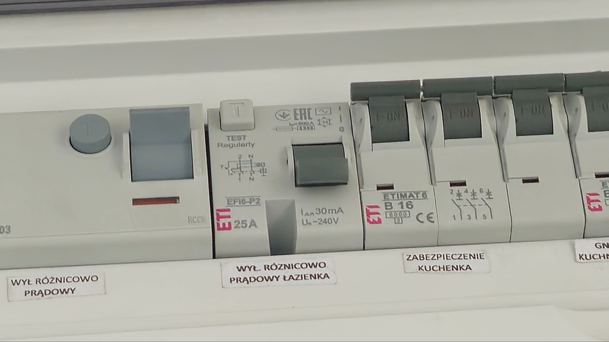 Szczegółowe ujęcie tablicy rozdzielczej z wyłącznikami różnicowoprądowymi i bezpiecznikami w Głubczycach. Widoczne oznaczenia i parametry urządzeń.
