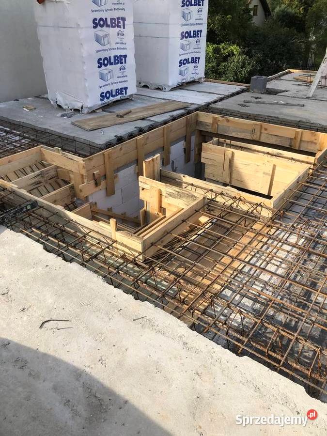 Zbrojenie i szalunek pod wylewkę na stropie budynku. Widoczne bloczki Solbet. Prace budowlane na etapie przygotowania do betonowania. Detal konstrukcji budynku.